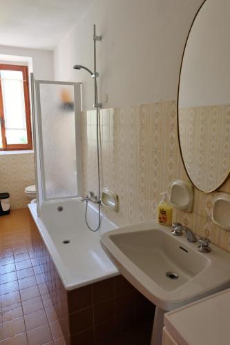 a bathroom with a shower and a sink and a mirror at La casa di Nonna Nilla in San Giovanni Bianco