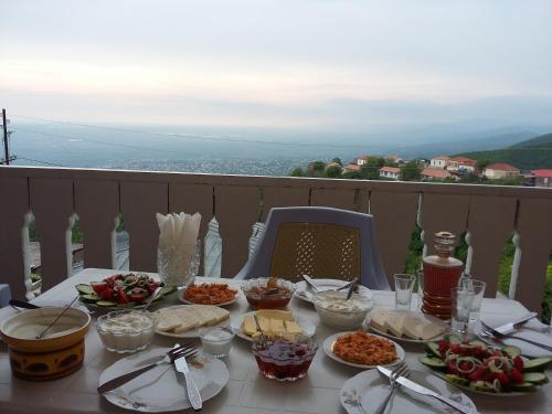 a table with plates of food on a balcony at Guest House Maria in Sighnaghi