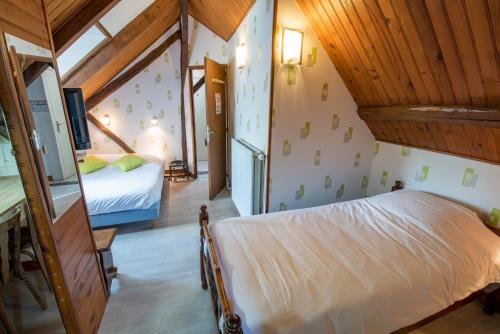 1 dormitorio con cama y techo de madera en Auberge De La Plaine en La Rothière