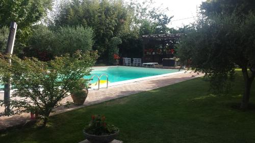 a swimming pool in a yard with trees and grass at Casa la Quiete in Torgiano