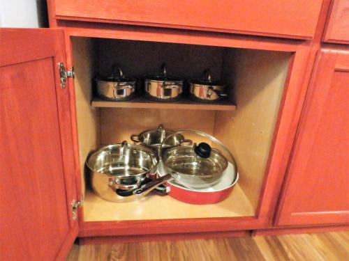 a cabinet with four pots and pans in it at NEW CHARMING 2 BEDROOMS UNIT CLOSE TO EVERYTHING in Oakhurst