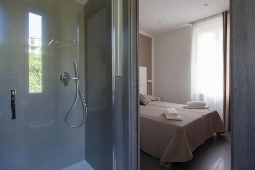 a bathroom with a shower and a bed in a room at Villino Wanda in Monterosso al Mare