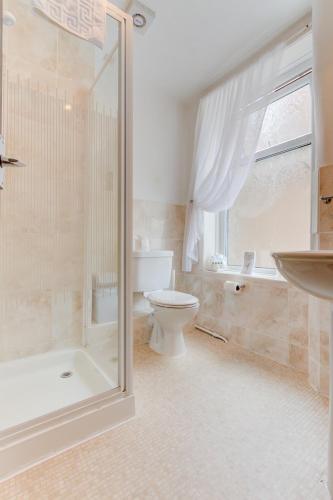 a bathroom with a shower and a toilet and a sink at The Strathdon in Blackpool