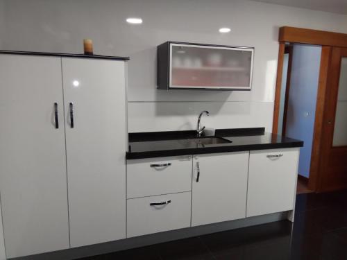 a kitchen with white cabinets and a sink at Apartamento La Ermita Wifi in Jerez de la Frontera