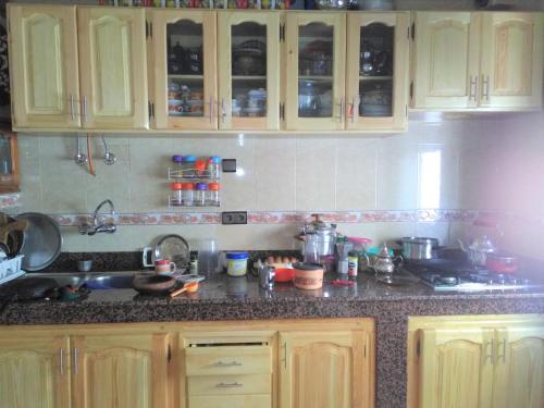 a kitchen with wooden cabinets and a counter top at Beach House in Asilah
