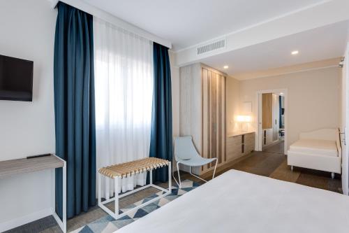 a hotel room with a bed and a tv at Hotel Europa in Garda