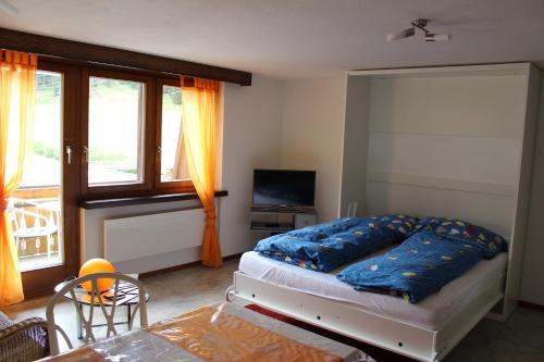 Un dormitorio con una cama con almohadas azules. en Ferienwohnung Silberdistel, en Saas-Grund