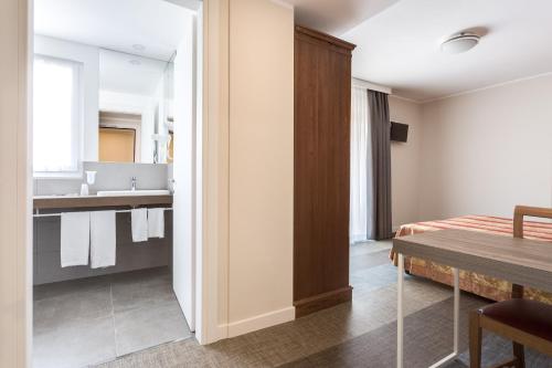 a bathroom with a sink and a bed in a room at Hotel Europa in Garda