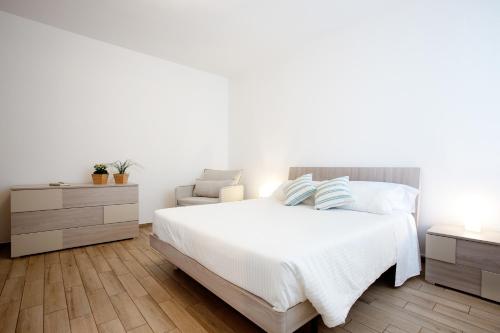 マリーナ・ディ・モーディカにある6Ventiの白いベッドルーム(ベッド1台、椅子付)