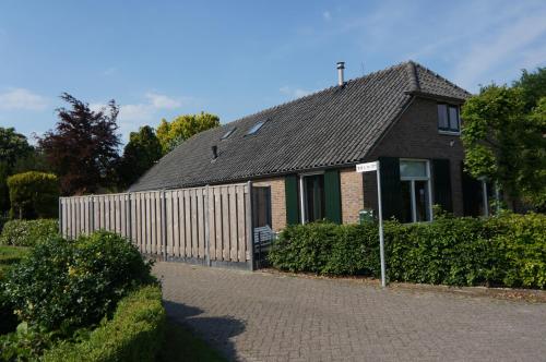a house with a wooden fence and a fence at Vakantiehuis in Oosterwolde