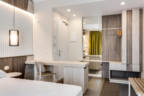 Schlafzimmer mit einem Bett, einem Schreibtisch und einem Spiegel in der Unterkunft Hotel Europa in Garda