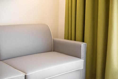 a white chair in front of a green curtain at Hotel Europa in Garda
