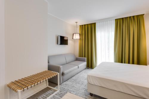 a hotel room with a bed and a couch at Hotel Europa in Garda