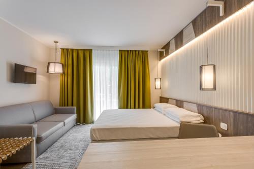 a hotel room with a bed and a couch at Hotel Europa in Garda