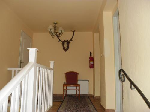 a stairway with a chair and a chandelier at Villa Meteor in Mariánské Lázně