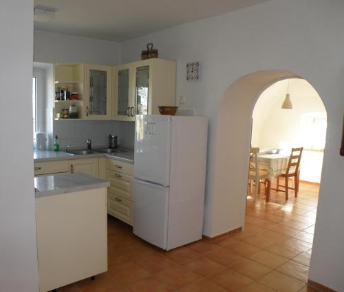 eine Küche mit einem weißen Kühlschrank und einem Tisch in der Unterkunft Idyllic place near Cerknica Lake in Cerknica