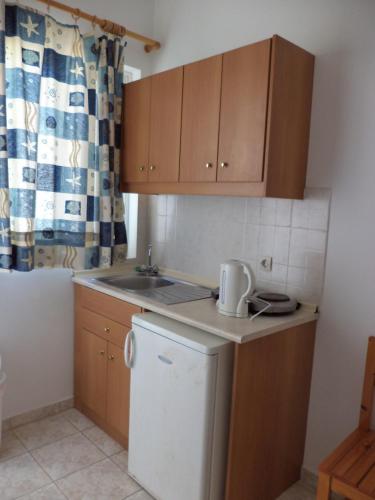 a kitchen with a white refrigerator and wooden cabinets at Haraki View in Haraki