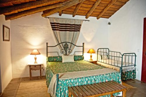 1 dormitorio con 1 cama en una habitación con techos de madera en Casa Saramago en Monsaraz