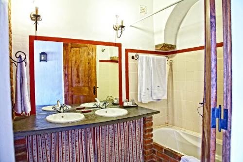 a bathroom with two sinks and a tub at Casa Saramago in Monsaraz