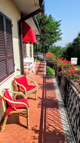 two chairs and an umbrella on a porch with flowers at Casavacanzedezza in Montecalvo Versiggia