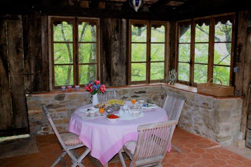 een eetkamer met een tafel met een roze tafelkleed bij Les Terrasses de Labade Gîte et Chambres d'hôtes in Coubisou