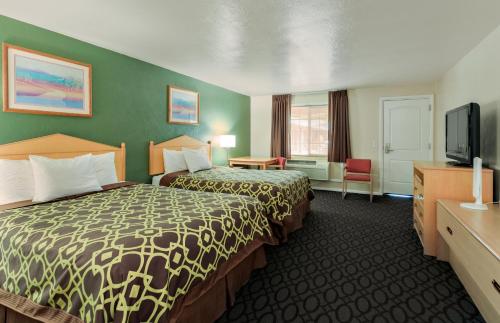 ユージンにあるDowntown Innのベッド2台、薄型テレビが備わるホテルルームです。