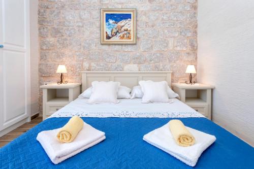 a bedroom with a blue bed with towels on it at Villa Riva in Jelsa