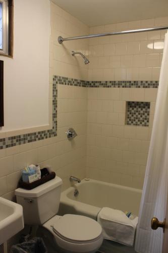 a bathroom with a toilet and a tub and a sink at Town & Beach Motel in Falmouth