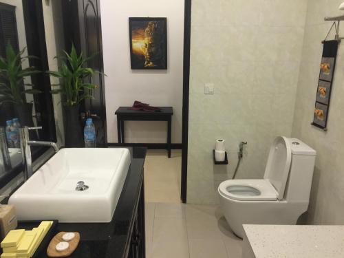 a bathroom with a white sink and a toilet at Private Boutique Home with Pool, The Fin Angkor Boutique in Siem Reap