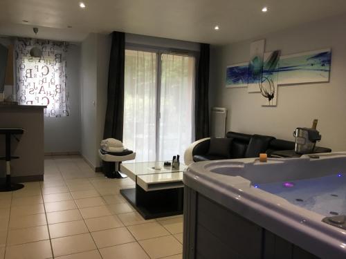 a living room with a tub and a couch at Appart&Spa in Toulouse