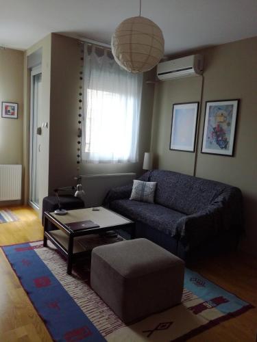 a living room with a couch and a table at Naissa Apartment in Niš