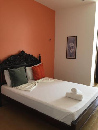 a bedroom with a large bed with white sheets and colorful pillows at Beach Hotel Jacuma in Jacumã