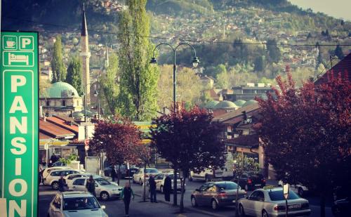 a busy city street with cars parked on the road at Pansion Fočin Han in Sarajevo