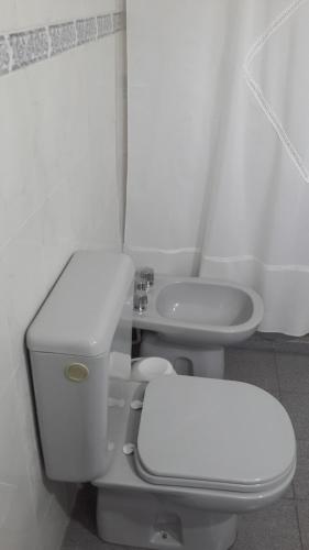 
a white toilet sitting in a bathroom next to a sink at Oasis Gran Hotel in Villa Carlos Paz
