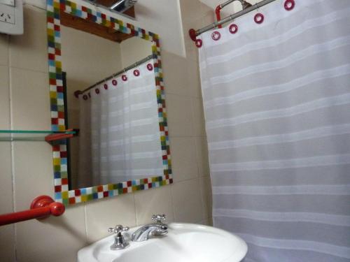 y baño con lavabo, espejo y ducha. en Cabañas Las Lavandas en El Bolsón