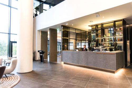 a man sitting at a counter in a lobby at Hotel Nanta Jeju in Jeju