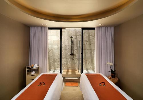 two beds in a room with a shower at Paradisus Los Cabos - Adults Only - All Inclusive in Cabo San Lucas