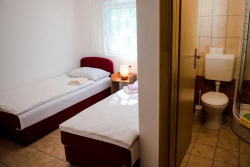 a small room with two beds and a toilet at Family guesthouse in forest Ana & Stjepan Nikolić in Međugorje