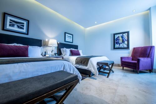 Pokój hotelowy z 2 łóżkami i fioletowym krzesłem w obiekcie Square Small Luxury Hotel - Providencia w mieście Guadalajara