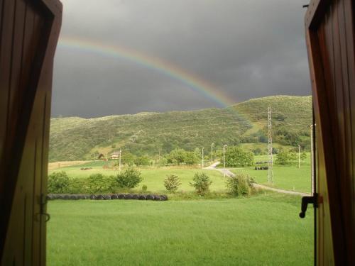 a rainbow from a window with a green field at La Mies in Rasines