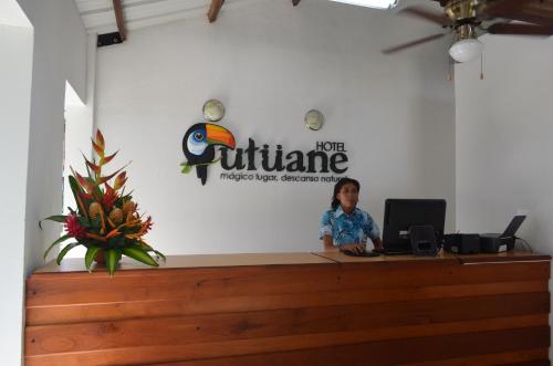 a man sitting at a counter in a office at Hotel Utüane in Leticia