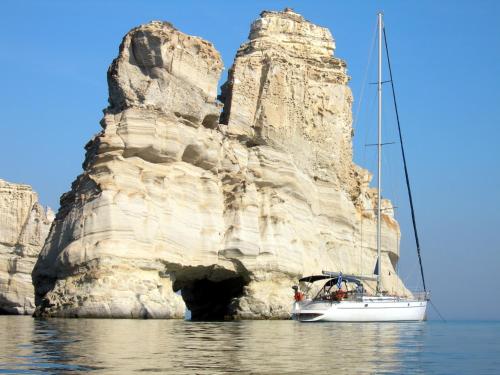 a boat in the water next to a rock formation at Hotel Eleni in Adamas