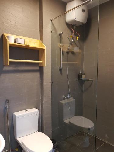 a bathroom with a toilet and a glass shower stall at Tia Du Villa Homestay in Da Lat