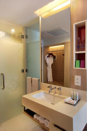 a bathroom with a sink and a large mirror at Mercure Bali Nusa Dua in Nusa Dua