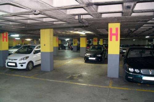 a parking garage with three cars parked in it at Hotel Castilla Vieja in Palencia