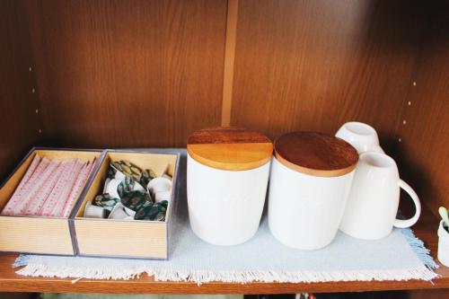 two white cups and a box on a table at Guesthouse Ogawaya in Tanabe