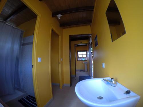 a bathroom with a sink and a yellow wall at Painapaopao Backpacker in Moorea