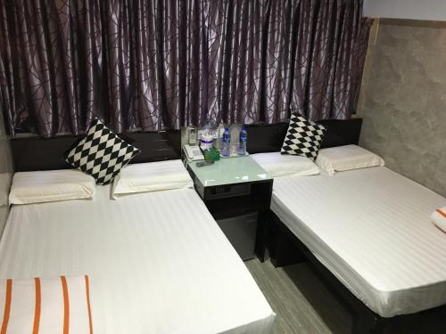 a group of three beds in a room at Victoria Inn in Hong Kong