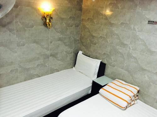a small room with two beds and a lamp at Victoria Inn in Hong Kong