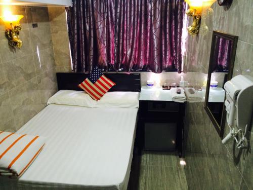 a small room with a bed and a sink at Victoria Inn in Hong Kong